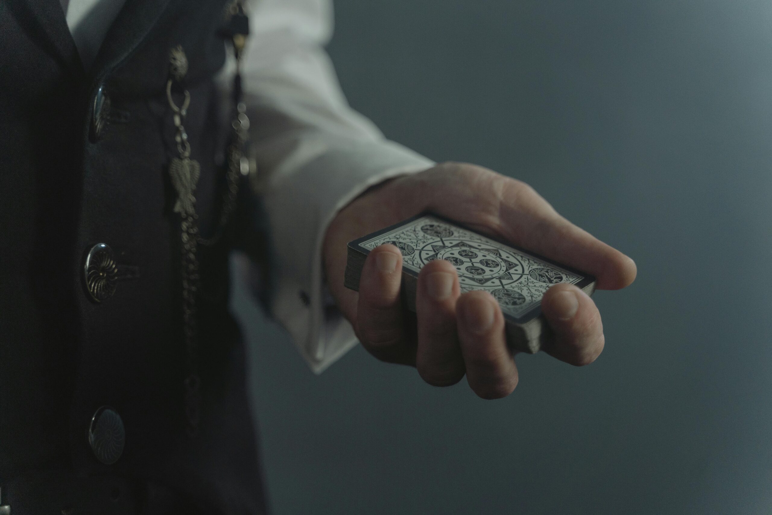 A magician's hand holding a detailed deck of cards, ready for a trick.